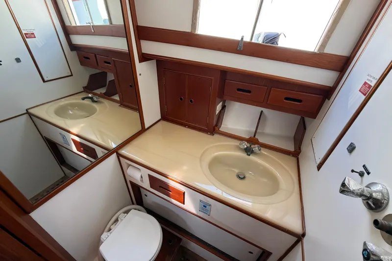  Yacht Photos Pics Bathroom interior of 1990 Grand Banks 42 Classic yacht with sink and wooden cabinetry.