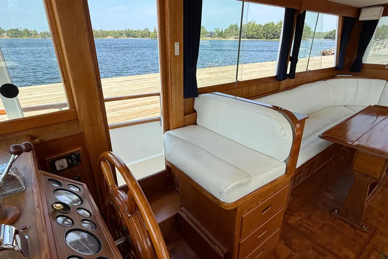  Yacht Photos Pics Interior of 1990 Grand Banks 42 Classic yacht with wooden helm and white seating.