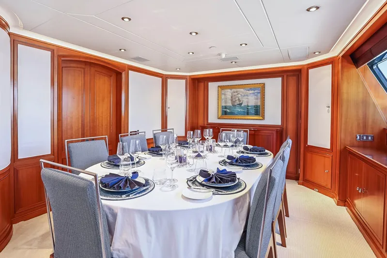 Zenji Yacht Photos Pics Luxurious dining room on 2004 Perini Navi 56m yacht, elegantly set table, wooden paneling.