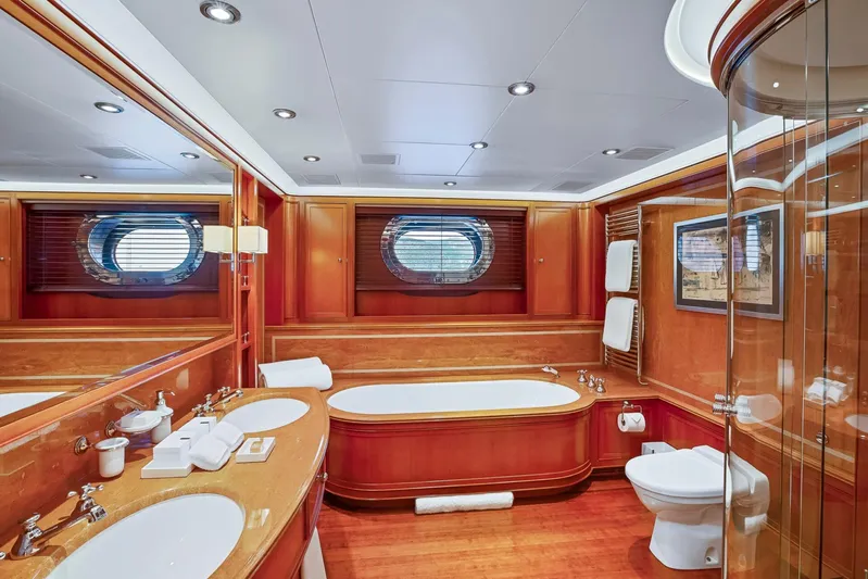 Zenji Yacht Photos Pics Luxurious yacht bathroom with wood accents, oval bathtub, and porthole window on a 2004 Perini Navi 56m.