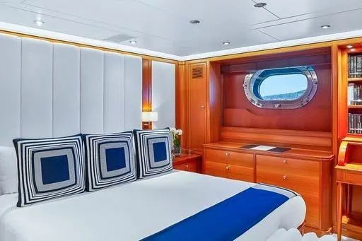 Zenji Yacht Photos Pics Luxurious cabin interior of 2004 Perini Navi 56m yacht with elegant wood finishes and porthole view.
