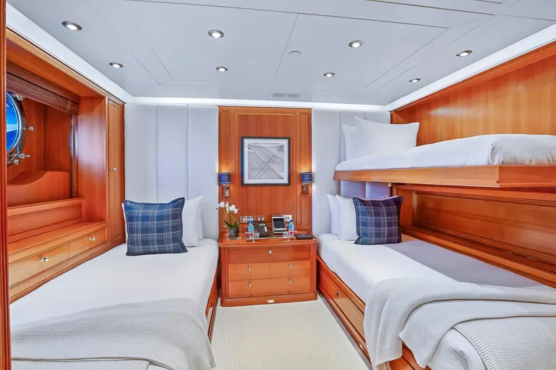 Zenji Yacht Photos Pics Luxurious cabin interior of 2004 Perini Navi 56m yacht with wooden furnishings and cozy bedding.