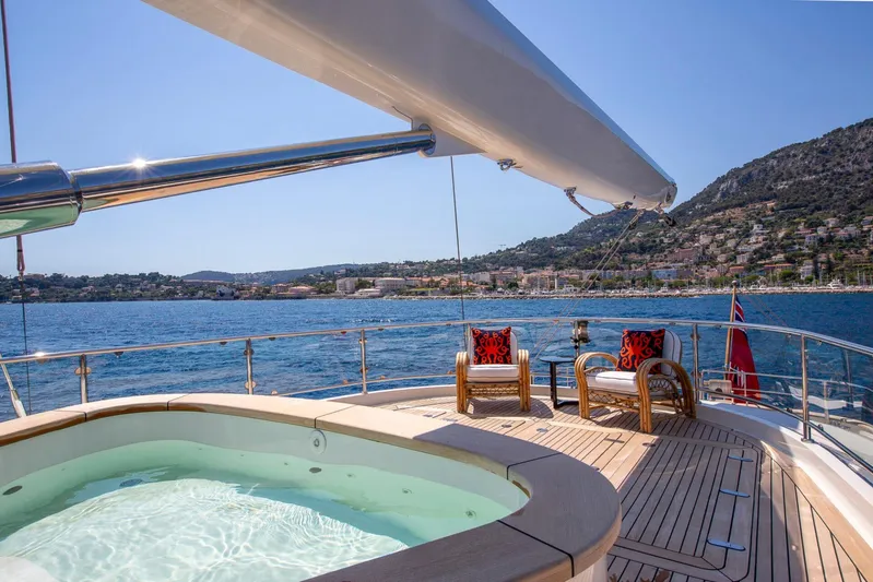 Zenji Yacht Photos Pics Luxurious Perini Navi 56m yacht deck with jacuzzi, scenic coastal view, and elegant seating, 2004 model.