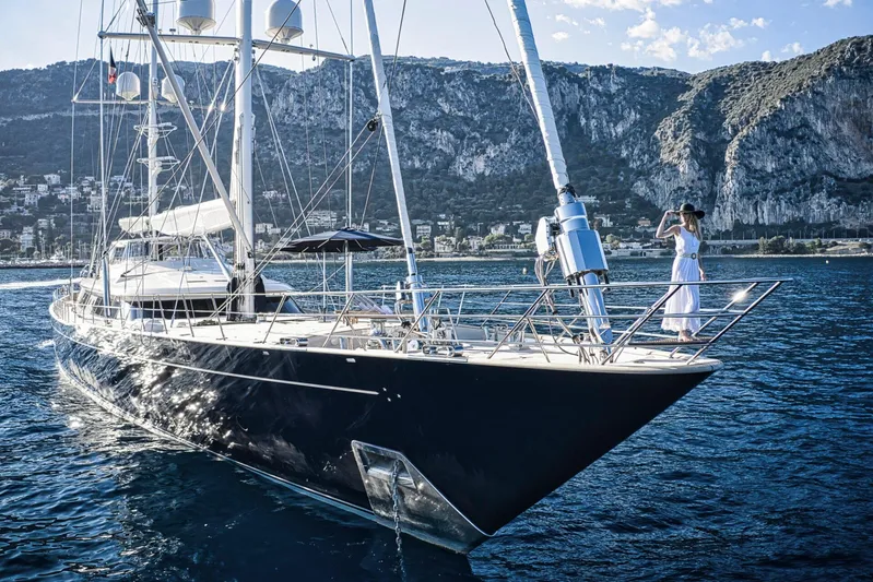 Zenji Yacht Photos Pics Luxury Perini Navi 56m yacht sailing near scenic coastal cliffs, 2004 model.