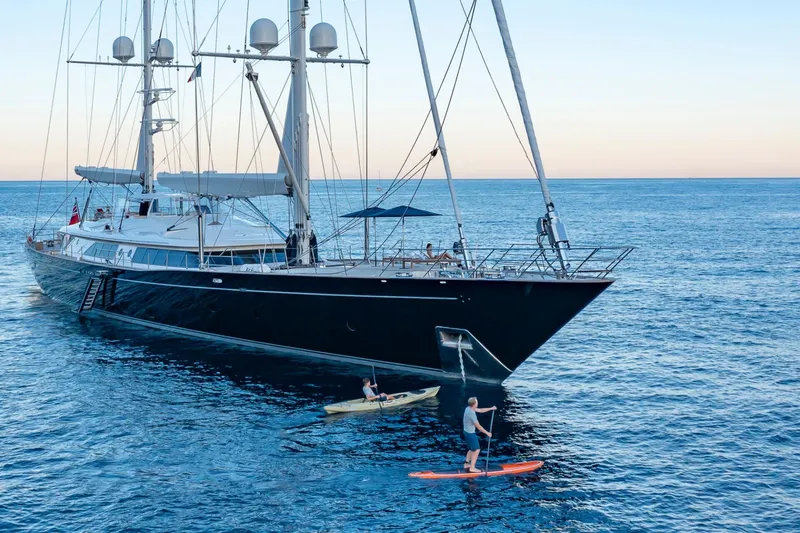 Zenji Yacht Photos Pics Luxurious 2004 Perini Navi 56m yacht with kayakers and paddleboarder on serene ocean.