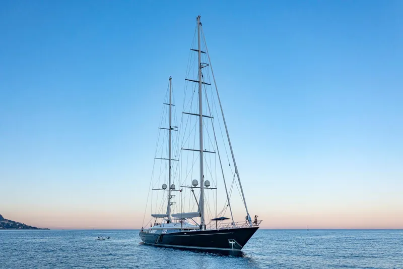 Zenji Yacht Photos Pics Luxurious 2004 Perini Navi 56m yacht sailing at sunset on calm waters.