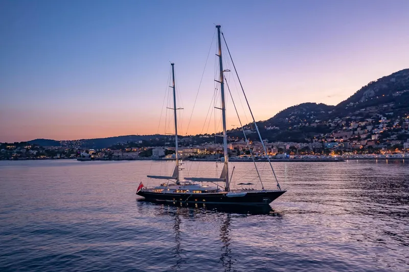 Zenji Yacht Photos Pics Sailing yacht Perini Navi 56m, 2004, at sunset near coastal town.
