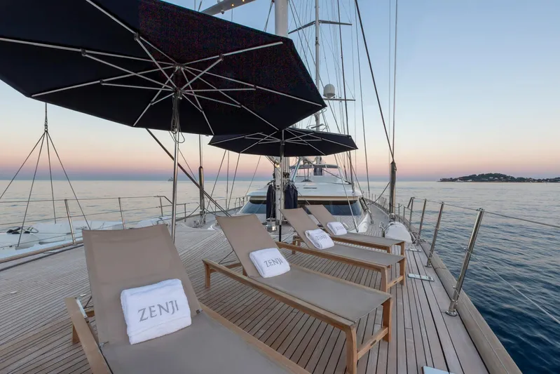 Zenji Yacht Photos Pics Luxurious Perini Navi 56m yacht deck with sun loungers and umbrellas at sunset, 2004 model.