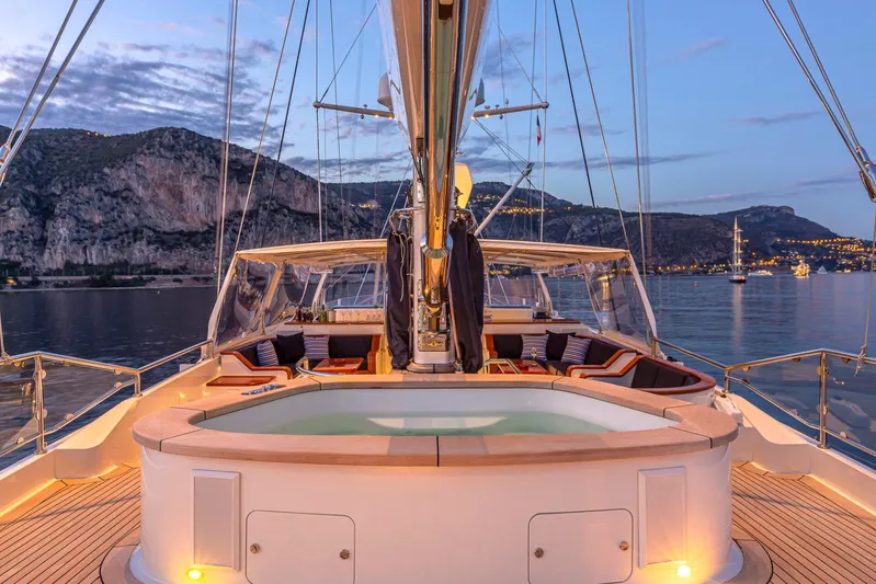Zenji Yacht Photos Pics Luxurious Perini Navi 56m yacht deck with jacuzzi, scenic coastal backdrop, 2004 model.