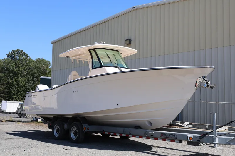  Yacht Photos Pics 2026 Grady-White Canyon 306 boat on trailer, parked outdoors near a building.