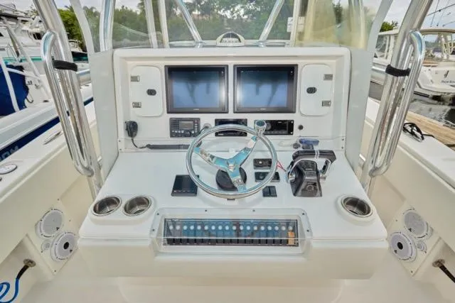  Yacht Photos Pics Control panel of a 2015 Invincible 36 boat with dual screens and steering wheel.