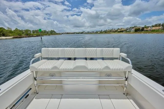  Yacht Photos Pics Invincible 36 boat, 2015 model, featuring white seating, cruising on a scenic waterway.