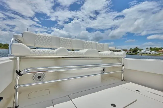  Yacht Photos Pics Invincible 36 boat interior, 2015 model, featuring white cushioned seating under a blue sky.