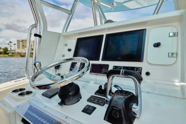  Yacht Photos Pics Control panel of a 2015 Invincible 36 boat with steering wheel and navigation screens.