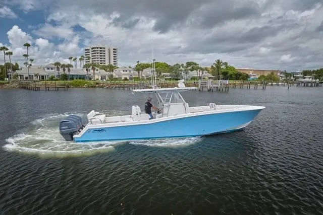  Yacht Photos Pics 2015 Invincible 36 boat cruising on a calm waterway under cloudy skies.