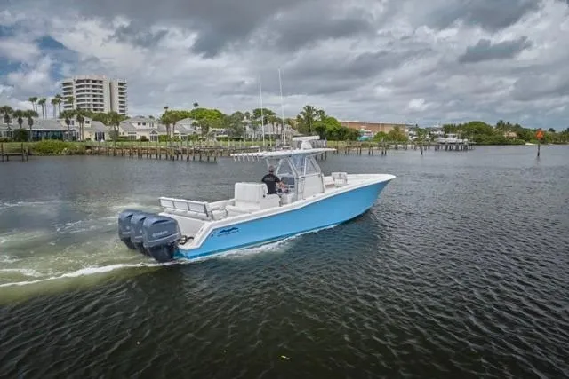  Yacht Photos Pics 2015 Invincible 36 boat cruising on a calm river under cloudy skies.