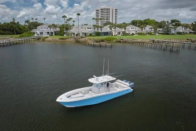  Yacht Photos Pics 2015 Invincible 36 boat on calm water near waterfront homes.