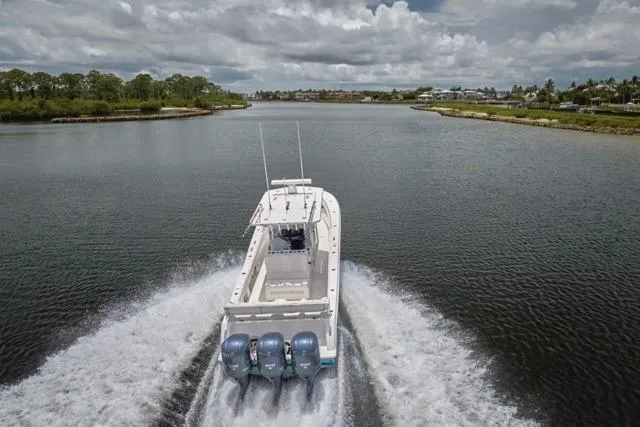  Yacht Photos Pics Invincible 36 boat cruising on a river, 2015 model, with triple outboard engines.