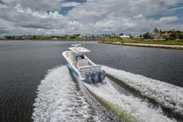  Yacht Photos Pics Invincible 36 boat cruising on water, 2015 model, with triple engines, scenic background.