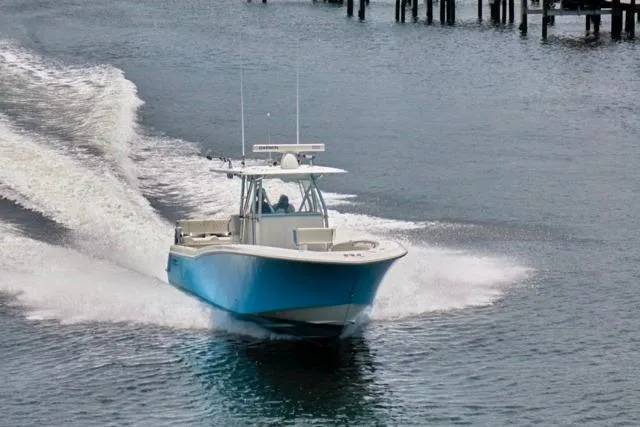  Yacht Photos Pics 2015 Invincible 36 boat cruising on water near docks.