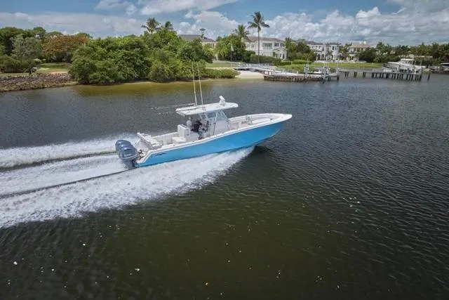  Yacht Photos Pics 2015 Invincible 36 boat cruising on a scenic waterway with lush greenery.