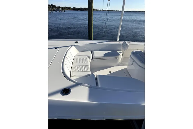  Yacht Photos Pics 2024 Contender 25 Bay boat interior with white cushioned seating by the water.