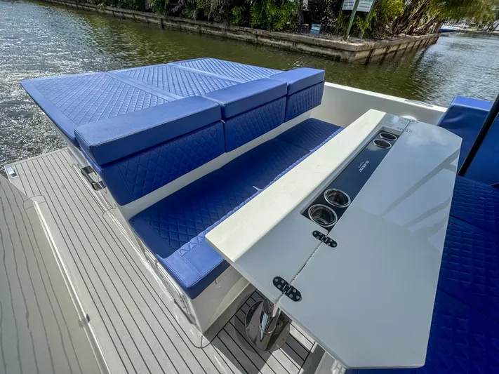  Yacht Photos Pics 2024 De Antonio Yachts D28 Open with blue seating and sleek table on deck.