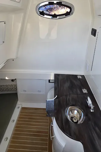 Wound Tight Yacht Photos Pics 2021 Regulator 34 Center Console interior with sink and wooden flooring.