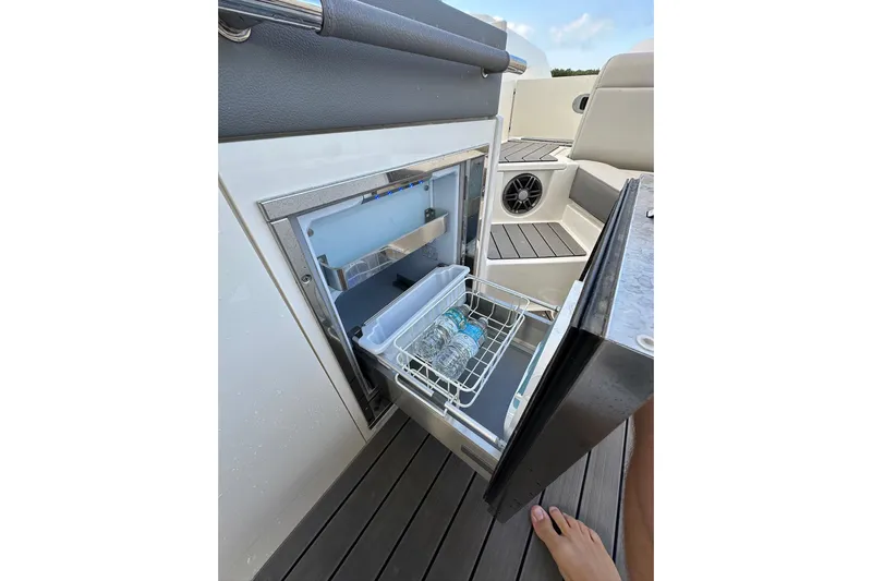Northeast Yacht Photos Pics Open mini fridge on 2022 Sea Ray SLX 350 Outboard boat with water bottles inside.