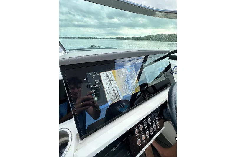Northeast Yacht Photos Pics 2022 Sea Ray SLX 350 Outboard dashboard with navigation display on a calm water backdrop.