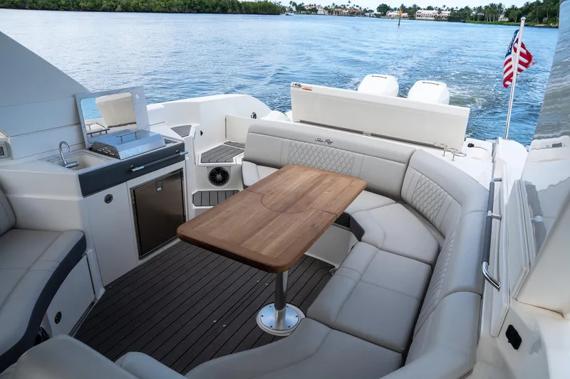 Northeast Yacht Photos Pics 2022 Sea Ray SLX 350 Outboard interior with seating, table, and kitchenette on a lake.