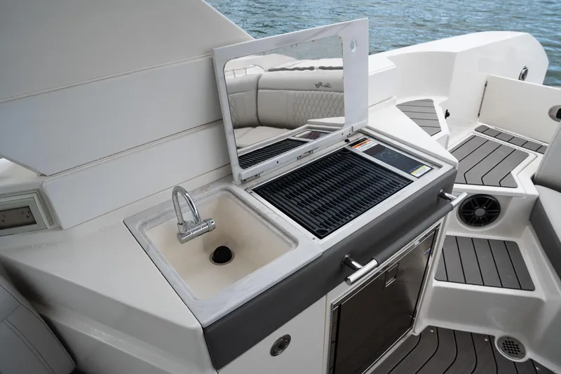 Northeast Yacht Photos Pics Luxury outdoor kitchen on 2022 Sea Ray SLX 350 Outboard boat, featuring sink and grill.