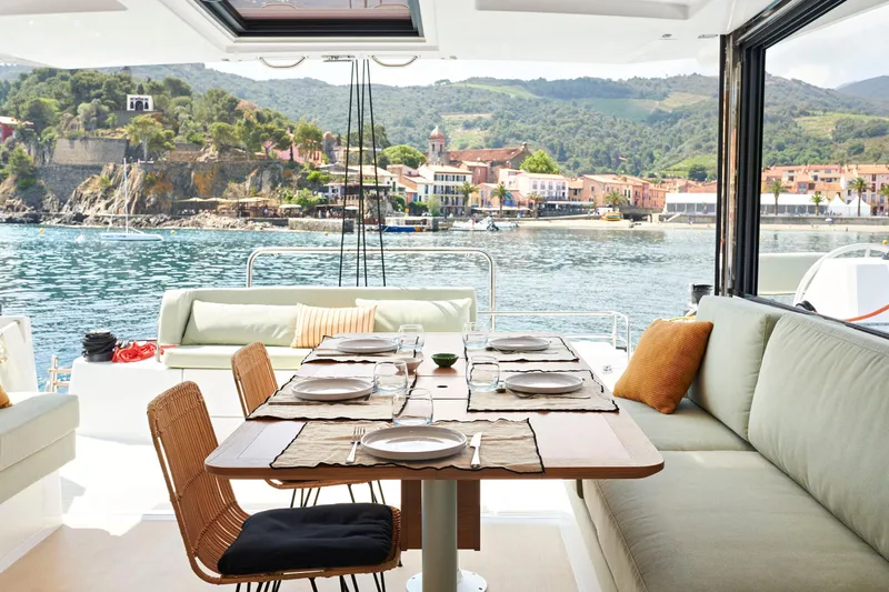  Yacht Photos Pics Luxurious Bali CATSMART 2026 yacht interior with dining area overlooking scenic coastal view.