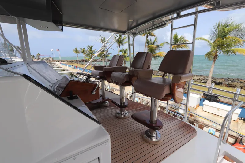 Bolita Yacht Photos Pics Luxury yacht helm with leather chairs, overlooking ocean and palm trees, Buddy Davis 74, 2002 model.