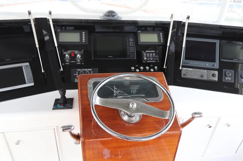 Bolita Yacht Photos Pics Control panel of a 2002 Buddy Davis 74 yacht with navigation instruments and steering wheel.