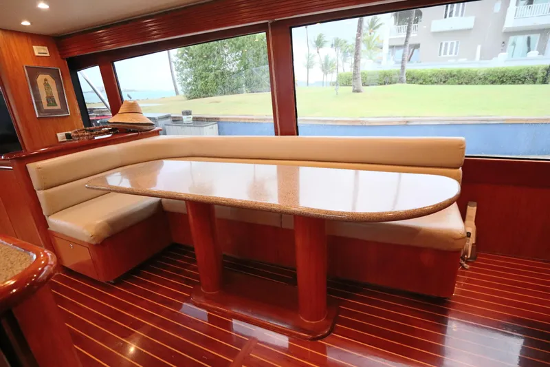Bolita Yacht Photos Pics Luxurious interior of 2002 Buddy Davis 74 yacht with elegant dining area and panoramic windows.