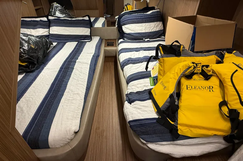  Yacht Photos Pics 2018 Chris-Craft Commander 44 cabin with striped bedding and yellow life jackets.