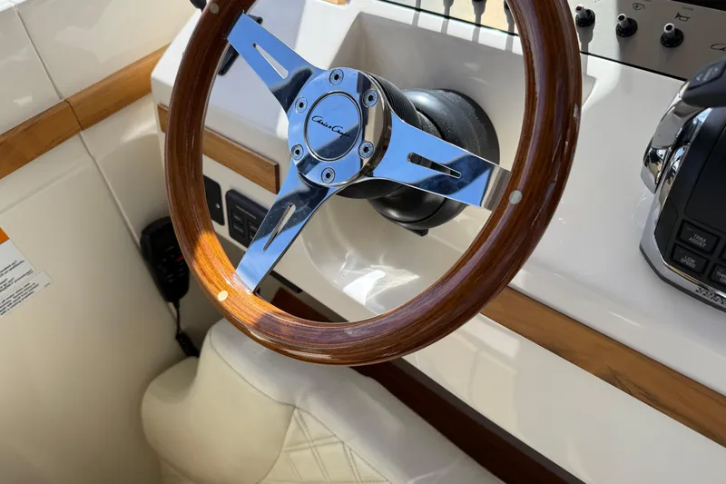  Yacht Photos Pics Steering wheel of 2018 Chris-Craft Commander 44 boat, featuring wood and chrome accents.