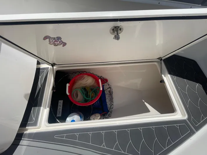 Motivated Yacht Photos Pics Open storage compartment on 2022 Contender 25 Tournament boat with fishing gear inside.
