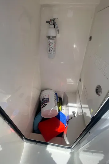 Motivated Yacht Photos Pics Storage compartment in a 2022 Contender 25 Tournament boat with fire extinguisher and supplies.