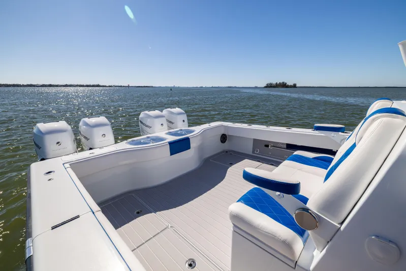  Yacht Photos Pics 2022 Freeman 42 LR boat with blue seating, ocean view, and multiple outboard engines.