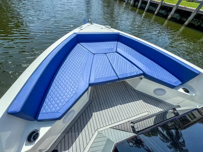  Yacht Photos Pics 2024 De Antonio Yachts D28 Open with blue seating, docked on calm water.