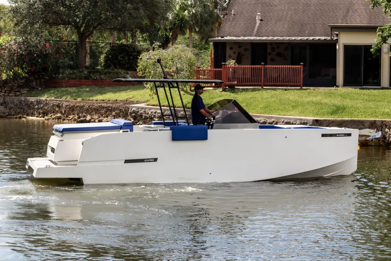  Yacht Photos Pics 2024 De Antonio Yachts D28 Open cruising on a calm waterway near a house.
