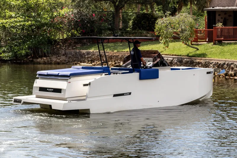  Yacht Photos Pics 2024 De Antonio Yachts D28 Open cruising on a serene waterway, surrounded by lush greenery.