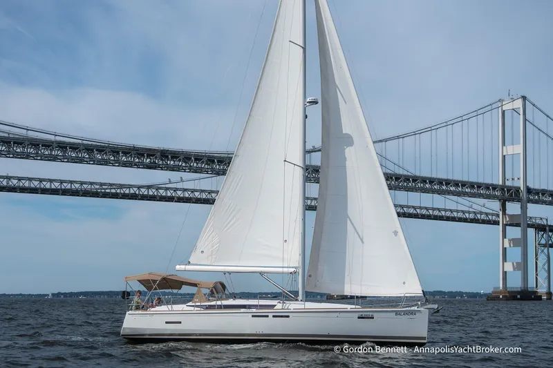 Balandra Yacht Photos Pics 2014 Jeanneau Sun Odyssey 439 sailing near a large bridge on a clear day.