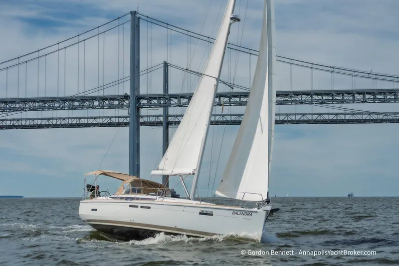 Balandra Yacht Photos Pics 2014 Jeanneau Sun Odyssey 439 sailing near a large bridge on open water.