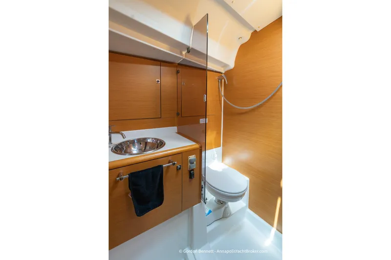 Balandra Yacht Photos Pics 2014 Jeanneau Sun Odyssey 439 bathroom with wooden cabinetry, stainless steel sink, and toilet.