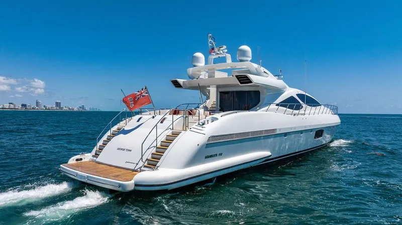Mixed Emotions Yacht Photos Pics Luxury 2014 Mangusta 110 yacht cruising on open sea under clear blue sky.