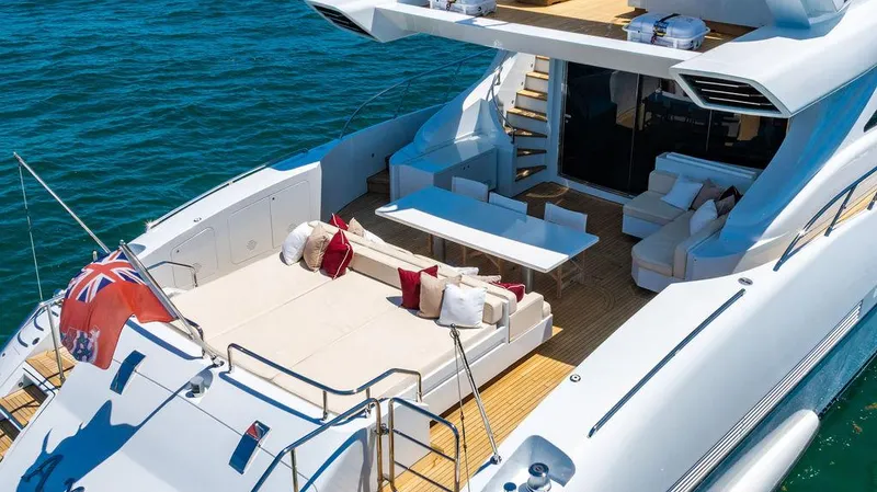 Mixed Emotions Yacht Photos Pics Luxurious 2014 Mangusta 110 yacht deck with seating, table, and ocean view.