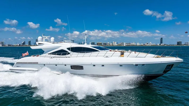 Mixed Emotions Yacht Photos Pics Luxury 2014 Mangusta 110 yacht cruising on open water with city skyline backdrop.